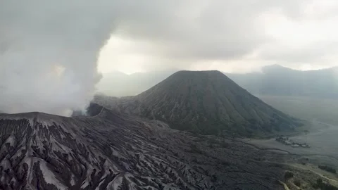 Cinematic Drone Dolly Back with Left Pan Revealing Smoking Volcano Stock Footage 315117691