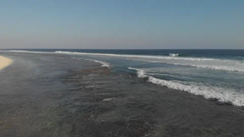 Cinematic drone filming the beach with waves crashing Vidéo 260287977