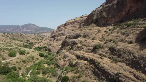 Cinematic drone flight alongside a steep and rocky mountain ridge. Stock Footage 154751407