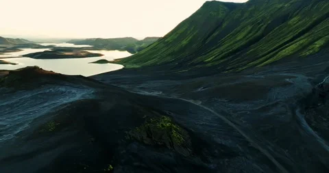 Cinematic drone flight over black volcanic ash plains toward calm Iceland Stock Footage 328359382