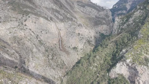 Cinematic Drone Flight Over Deep Canyon with Thin Waterfall - 4K Stock Footage 331765363