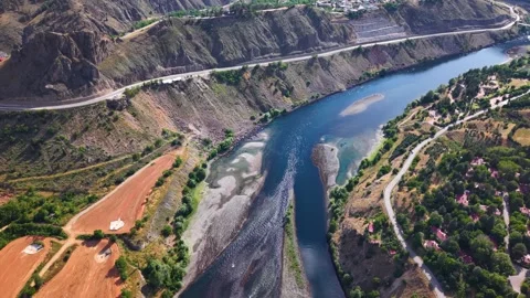 Cinematic Drone Flight Over Flowing River with Gradual Upward Camera Tilt Stock Footage 340249723