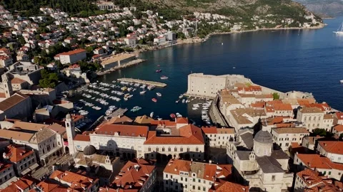 Cinematic drone flight over a historic coastal town and harbor Stock Footage 345118426