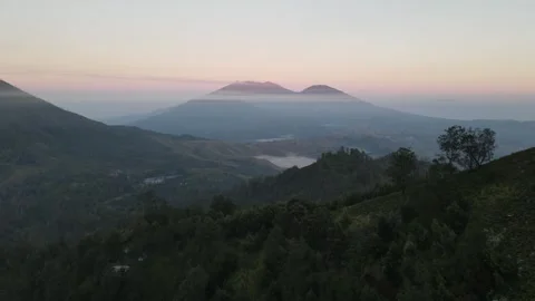 Cinematic Drone Flight Over Mountain Valley at Sunrise with Distant Peaks Stock Footage 260036885