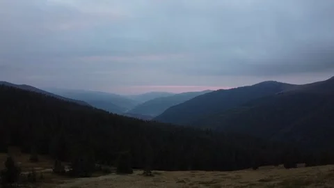 Cinematic drone flight over mountain meadow and forest at sunset time Stock Footage 337047783