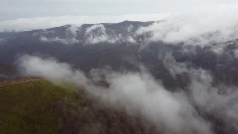 Cinematic drone flight over mountain ridge and rolling clouds Stock Footage 338104283
