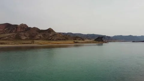 Cinematic drone flight over the River and blooming desert steppe in Central Asia Stock Footage 331574043