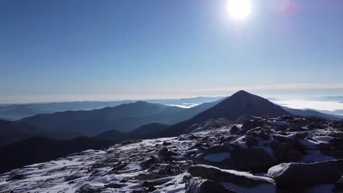 Cinematic drone flight over snow-dusted mountain peaks and rocks Stock Footage 339649269