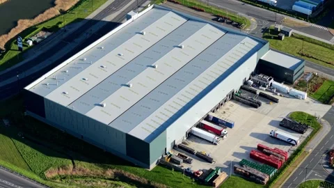 Cinematic drone flight over vast iPort logistics warehouses and rail freight Stock Footage 345209861