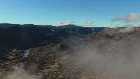 Cinematic Drone Fly Through Clouds to Reveal a Winding Turquoise River in a Video stock 333133246