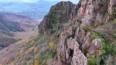 Cinematic Drone Flying Forward and Tracking Sharp Rocks in Autumn Forest, 4K Vídeos de archivo 335074813