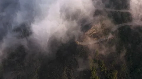 Cinematic drone footage on cloudscape flying above green landscape and highway 動画素材 165702824