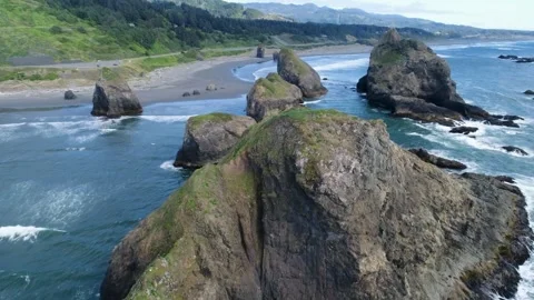 A cinematic drone footage glides forward above sea-stacks along Ariya’s Beach Stock Footage 341063642