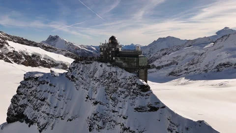 Cinematic drone footage the Sphinx Observatory with snow-covered mountain peaks Stock Footage 296590442