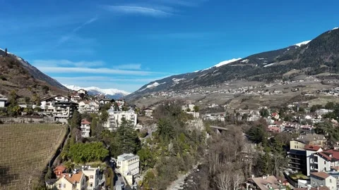 Cinematic Drone Forward Flight Over Sunny Alpine Town Along River with D Stock Footage 331746525