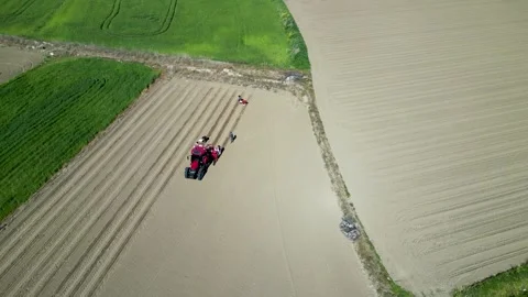 Cinematic Drone Orbit Shot Over Tractor and Workers in Large Farm Field Stock Footage 323196197