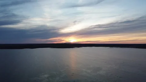 Cinematic drone pan of a dramatic sunset reflecting on the water. Stock Footage 312418124