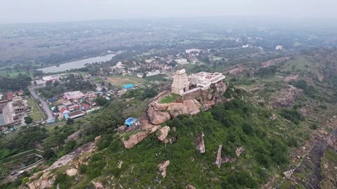 A cinematic drone pan view of Melkote temple on top of hill surrounded by s.. Stock-Footage 344877863