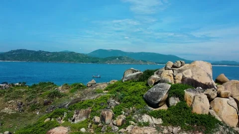 Cinematic drone pull back revealing rocky island peak and flying birds 4K Stock Footage 339378222