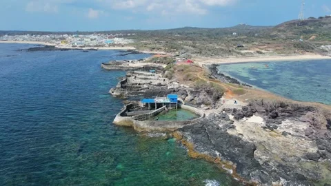 Cinematic drone pull back from seaside fish farming pools to ocean view 4K Stock Footage 336230411