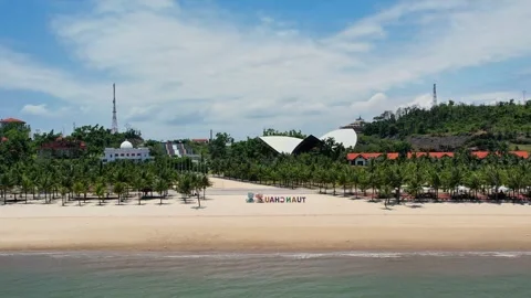 Cinematic drone pull back from a sun drenched golden beach to ocean 4K Stock Footage 336231401