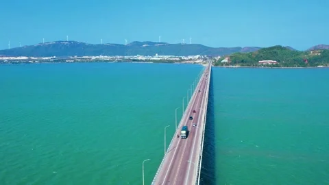 Cinematic drone pull back from Thi Nai Bridge over turquoise sea in Vietnam Stock Footage 334985543