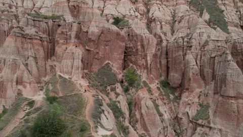 Cinematic drone pull-out revealing Rapa Rosie's red cliffs in Romania. Stock-Footage 309845355