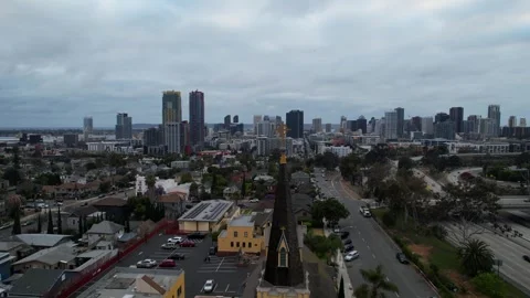 Cinematic drone pullback above a church with the San Diego skyline in the Video stock 333280127