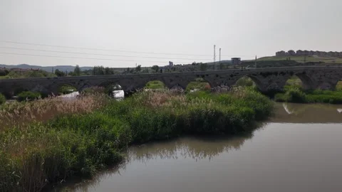 Cinematic Drone Pullback Over Historic White Stone Bridge with Reeds Video stock 336328016
