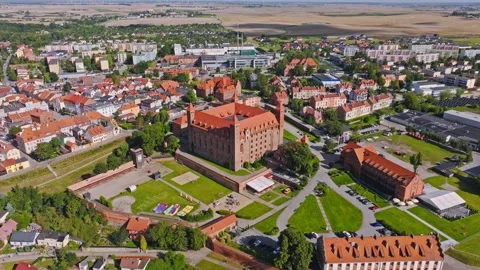 Cinematic drone pullback showing Gniew medieval castle under warm summer light Stock Footage 331967674