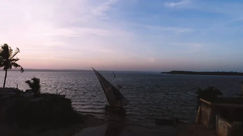 Cinematic drone push over boat launching into African sea at sunrise Stock Footage 104629986