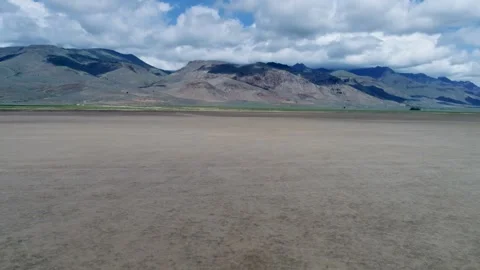 A cinematic drone racing backward low over the Alvord Desert salt flats Stock Footage 340931961