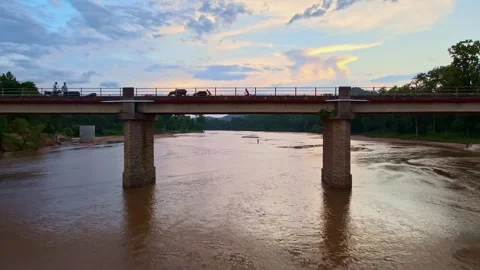 Cinematic drone shot of a bridge on a river with locals during beautiful sunset Stock Footage 249340044