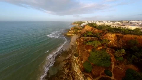 Cinematic drone shot of cliff beach with resort hotels nestled among cliffs Video stock 346091414