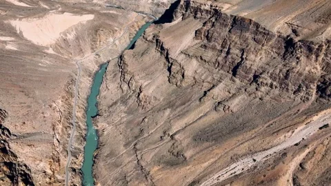 Cinematic drone Shot of a deep river gorge with rocky cliffs in the Himalayas. Video stock 333064757