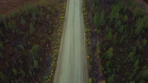 Cinematic drone shot flying over gravel road with trees. Stock Footage 163673620