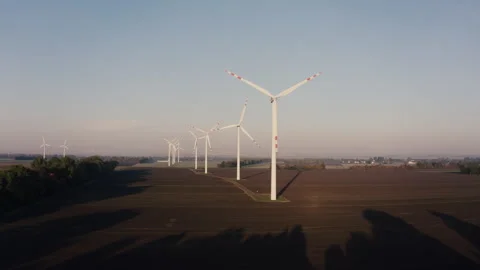 Cinematic drone shot Modern Wind Energy Farm In Countryside Under Sunset Sky Stock Footage 319954697