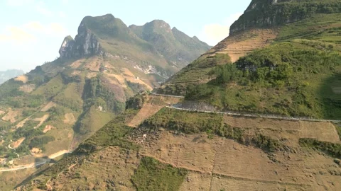 Cinematic drone shot of mountain depth and winding road – Ha Giang, Vietnam Video stock 313798383