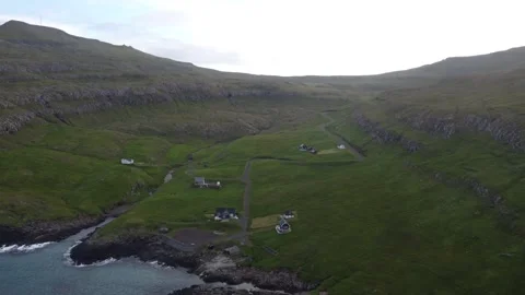 Cinematic drone shot, tiny four-house village Vikarbyrgi, green cliffs Suduroy Stock Footage 340168184