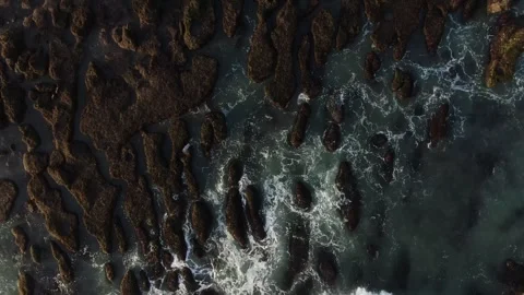 Cinematic drone shot waves hitting the rocks facing down Stock Footage 303629949