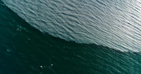 Cinematic drone static shot of glacial melt water mixing in deep blue fjord. 스톡 동영상 113716583