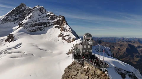Cinematic drone view of the Sphinx Observatory against the dramatic snowy Stock Footage 297180381