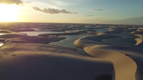 Cinematic drone view of sunset reflections across Lençóis Maranhenses lagoons Video stock 328190485