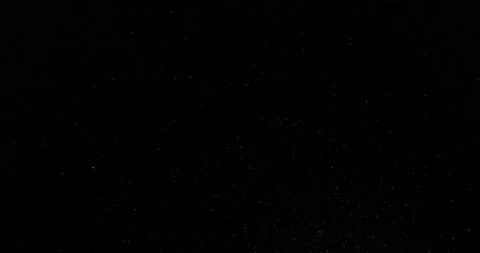 Cinematic dust particles floating on black background in slow motion. Atmosphere Vídeos de archivo 223597742