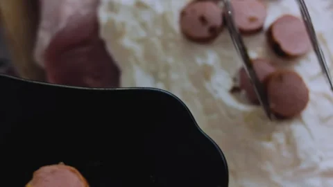 Cinematic dynamic preparation: slicing cooked sausage into rounds Stock Footage 342184494