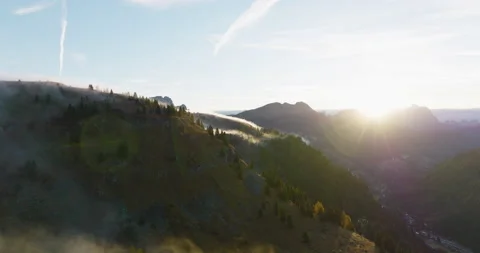 Cinematic flight over clouds passing mountains while sunset 5k Stock Footage 221903685