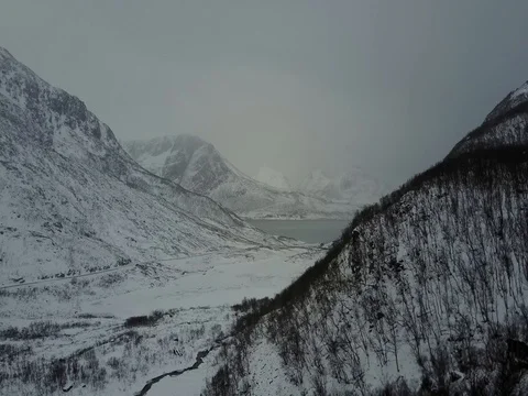 Cinematic fly over snowy fjord at Grotfjord near Tromso in winter Stock Footage