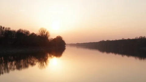 Cinematic flying over the river at sunset time. Golden Hour spring evening in 4k Stock Footage 127570398