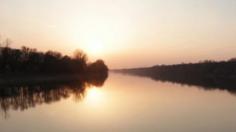 Cinematic flying over the river at sunset time. Golden Hour spring evening in 4k Stock Footage 127570403