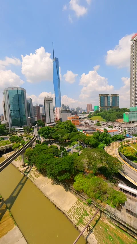 Cinematic FPV drone flight over LRT train tracks with Kuala Lumpur city skyline. Stock Footage 306516188